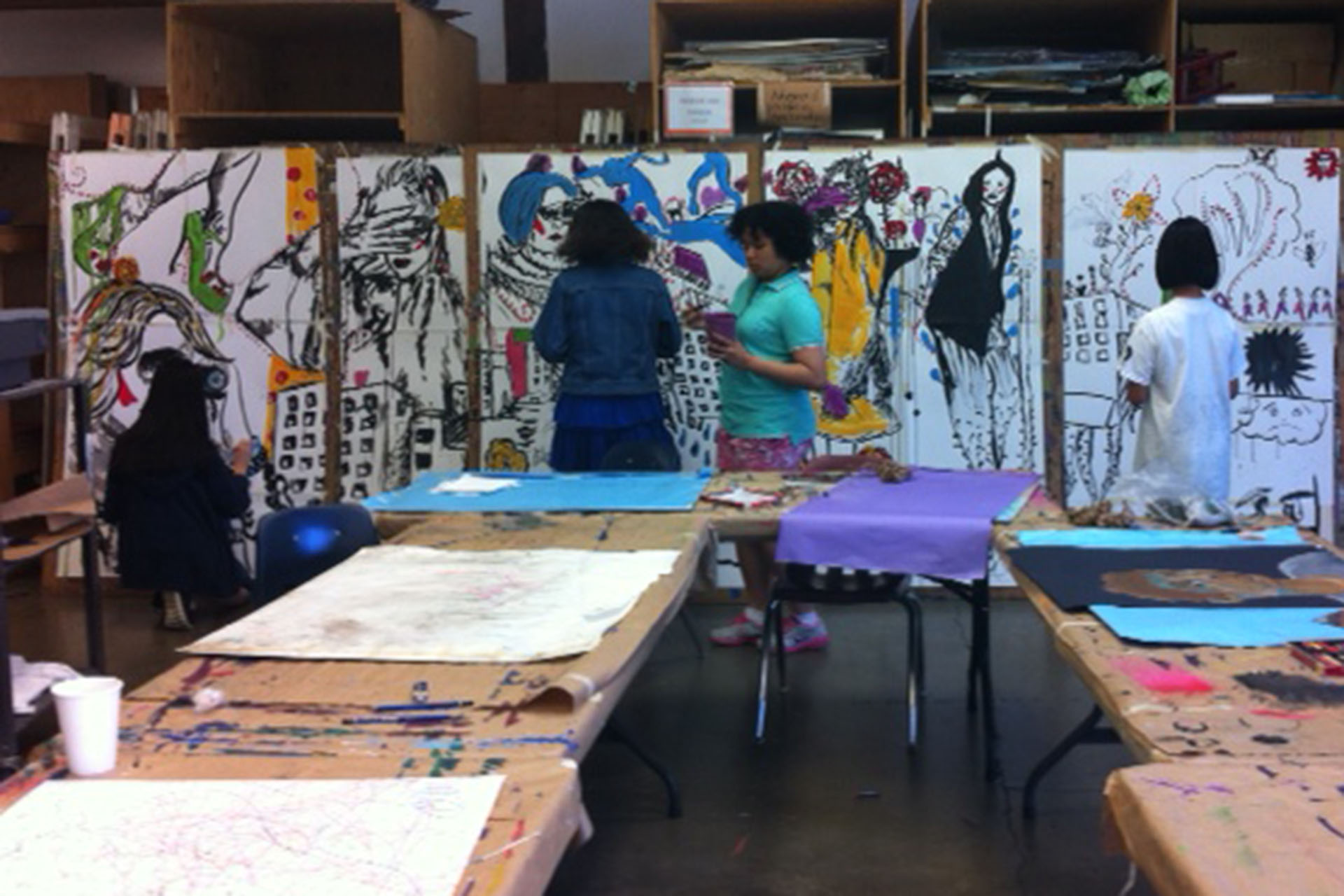 SEPTEMBER 2014: Young visual artists created an interactive mural for Vancouver Design Week, allowing the public to peek into our art studios. Pictured, are students creating the mural.